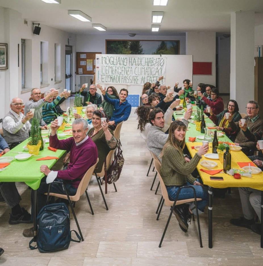 Foto di un eco-aperitivo in cui tutti brindano sorridenti.